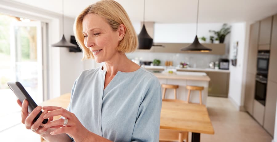 Woman holding a cell phone in a modern home
